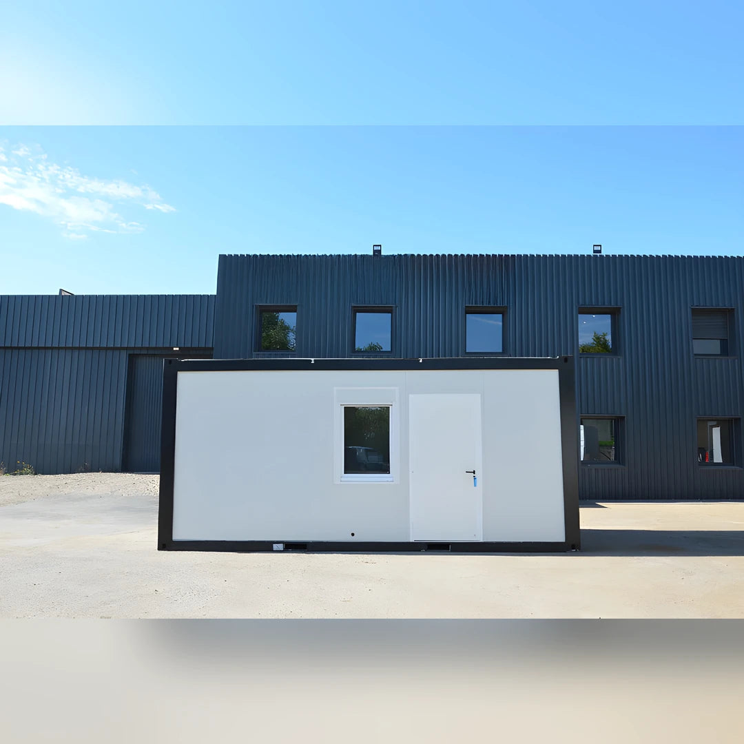 Bungalow bureau Eurocontex – façade avant avec fenêtre et porte, fond bâtiment industriel